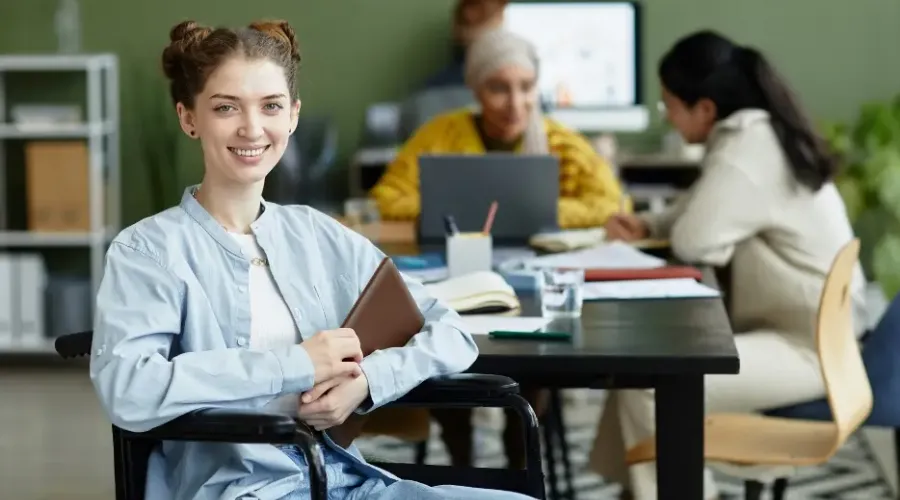 Young woman in a wheelchair smiling in an office environment